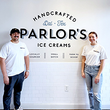 Kelly Stoll and husband in front of a Parlor's Handcrafted Ice Creams sign