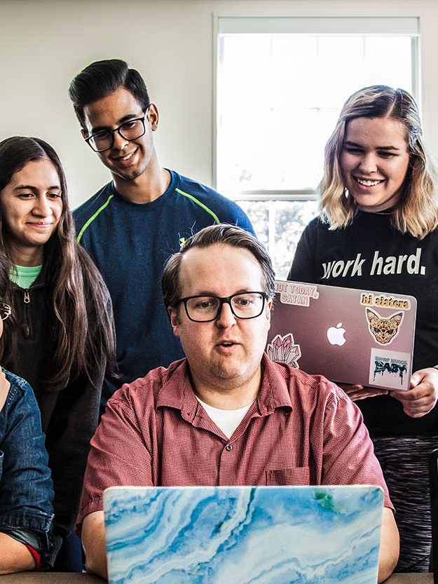 Faculty and students at desk