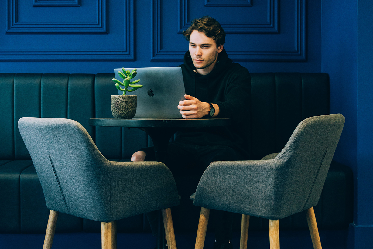 Man sitting at a table using a laptop