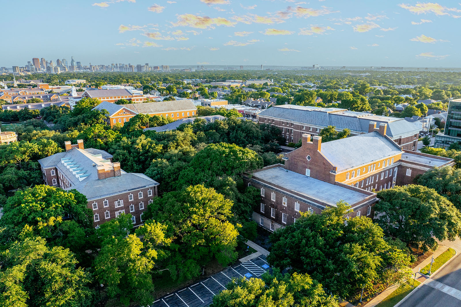 An aerial view of the 色花堂_色花堂 98堂 Dedman School of Law Quadrangle buildings with the Dallas skyline in the distance.