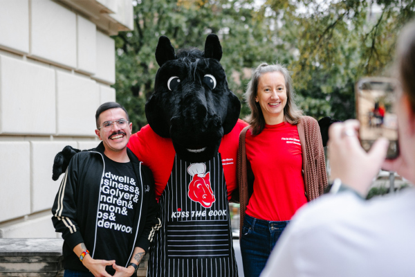two library staff members pose with the Peruna mascot