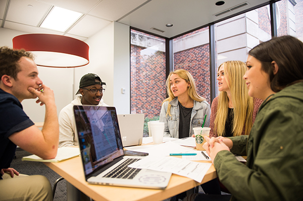 five students meeting around a study room table