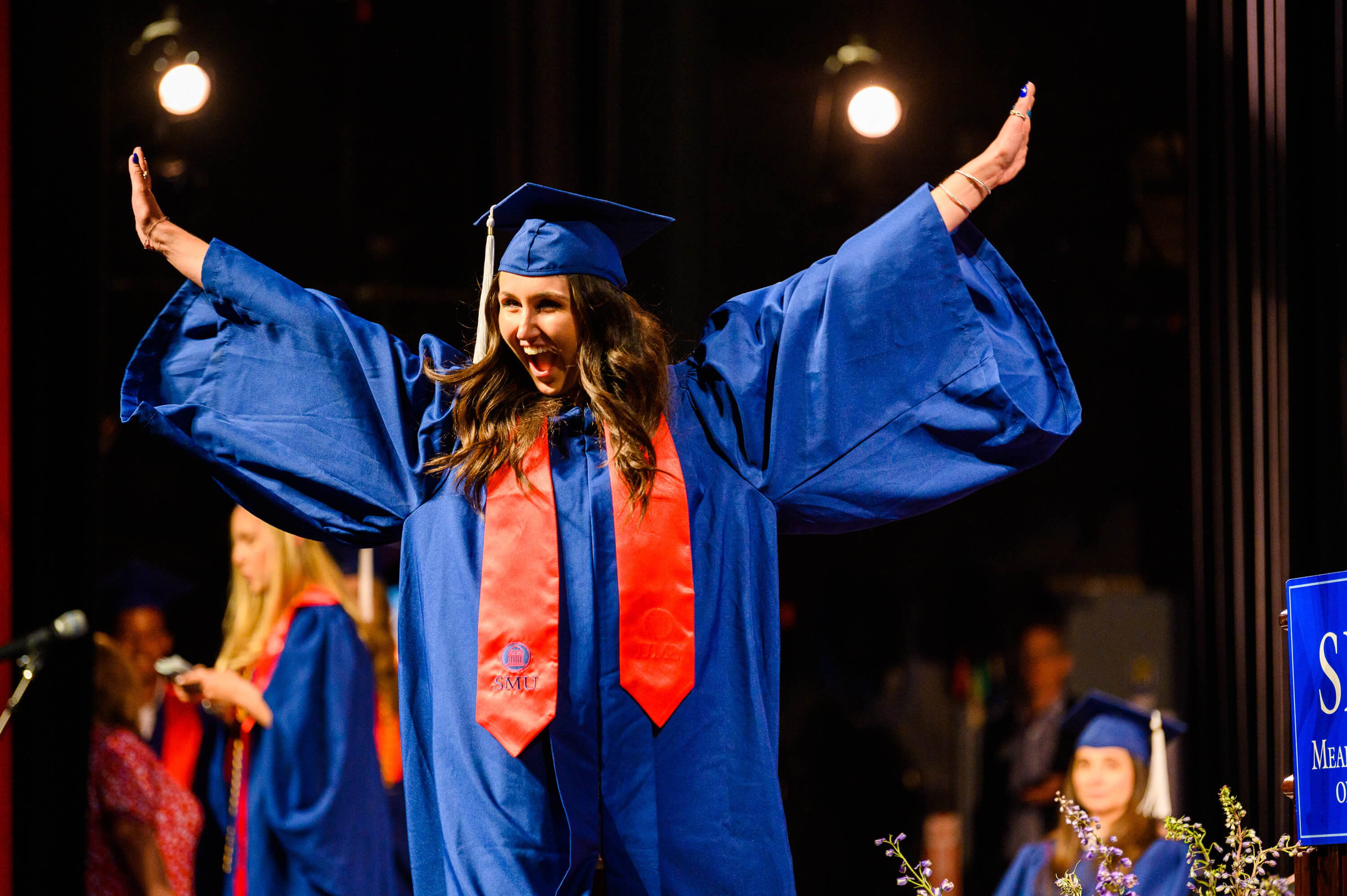 Graduation2022_FemaleStudentArmsRaised