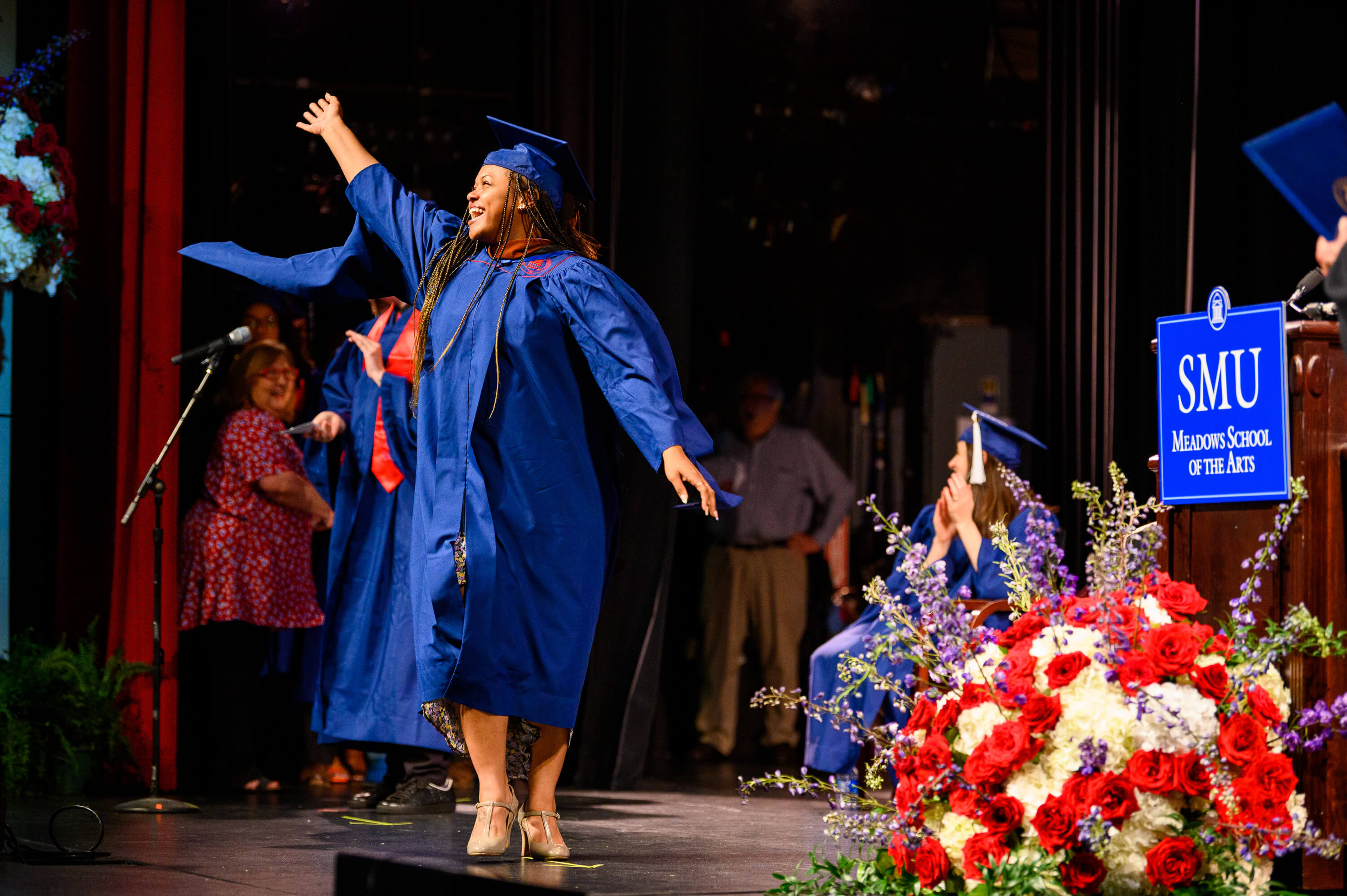 Graduation2022_StudentWavingAcrossStage