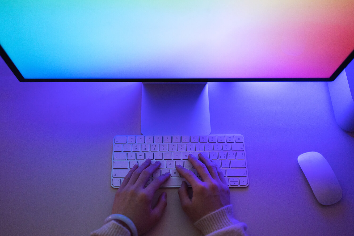 hands on a keyboard with computer screen in view