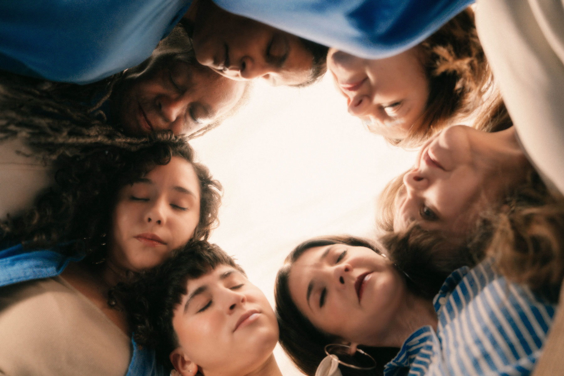 Women lean on each other in a circle