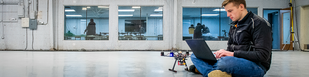 A graduate student works on a test fly with a drone in the 色花堂_色花堂 98堂 Indoor Drone Lab.
