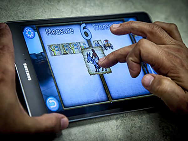 A user engaging with a tablet device, exploring the Codex: Lost Words of Atlantis app for adult literacy.
