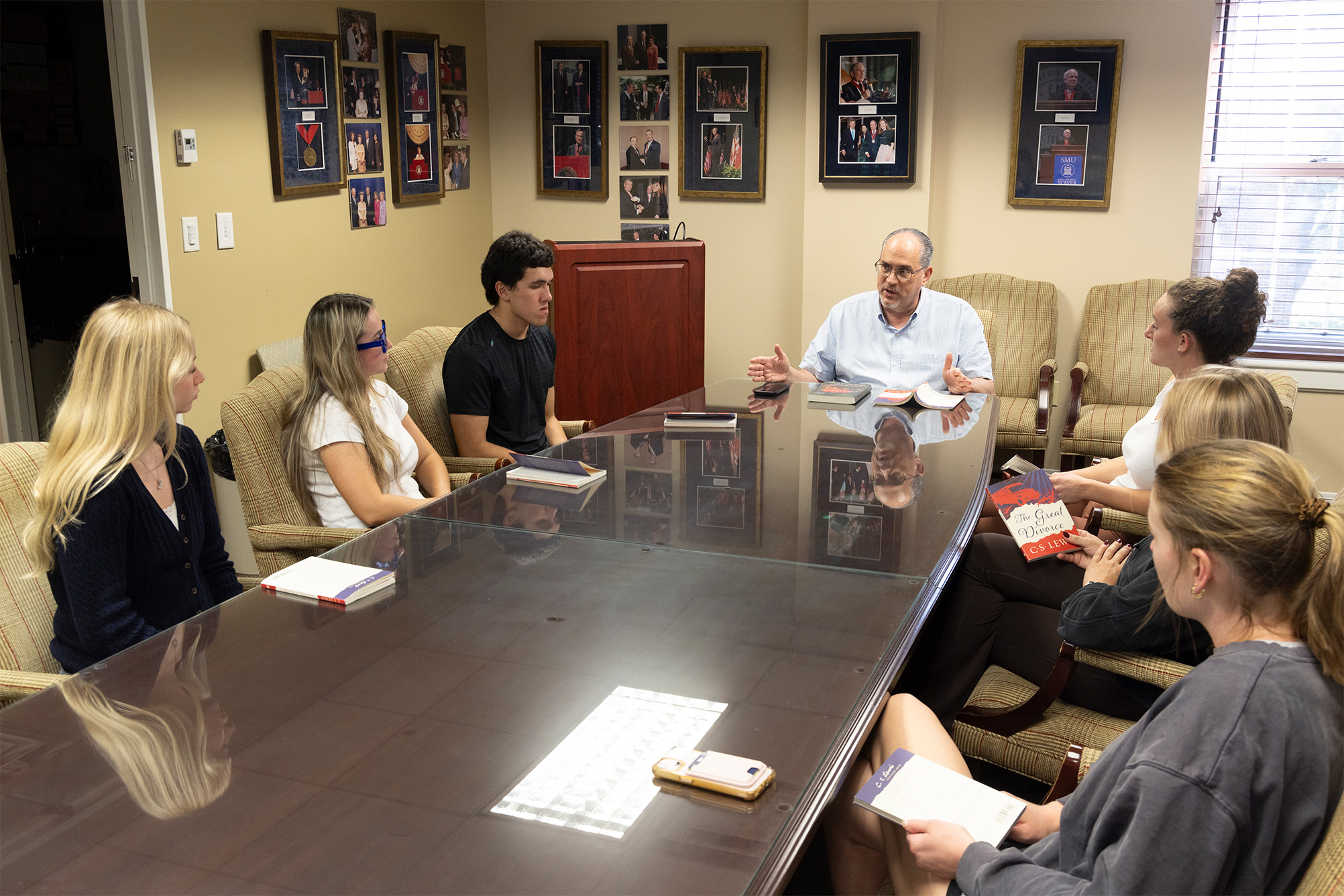 students and professor sitting at long conference table talking