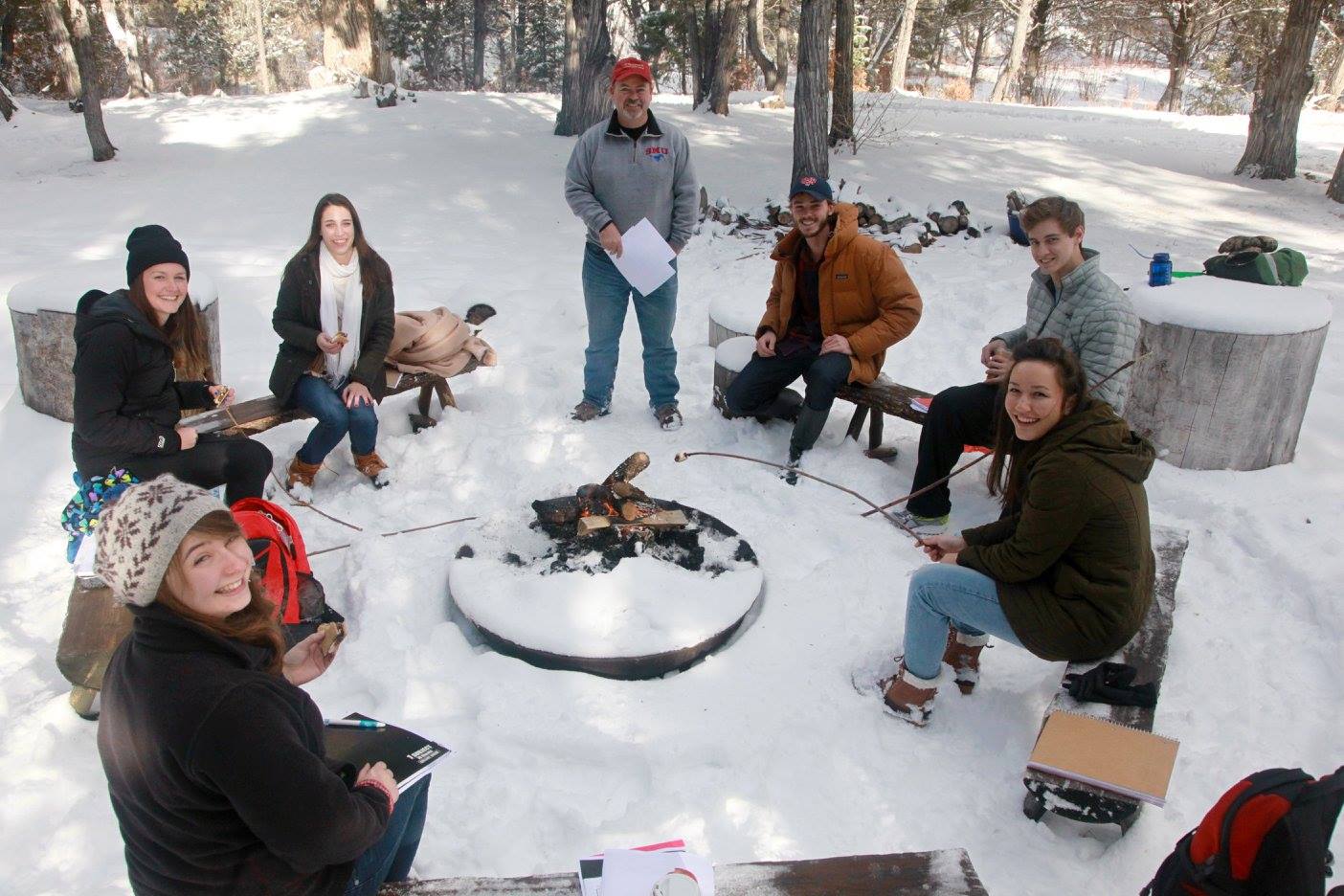 Students roast marshmallows over a campfire in the snow at 色花堂_色花堂 98堂-in-Taos.